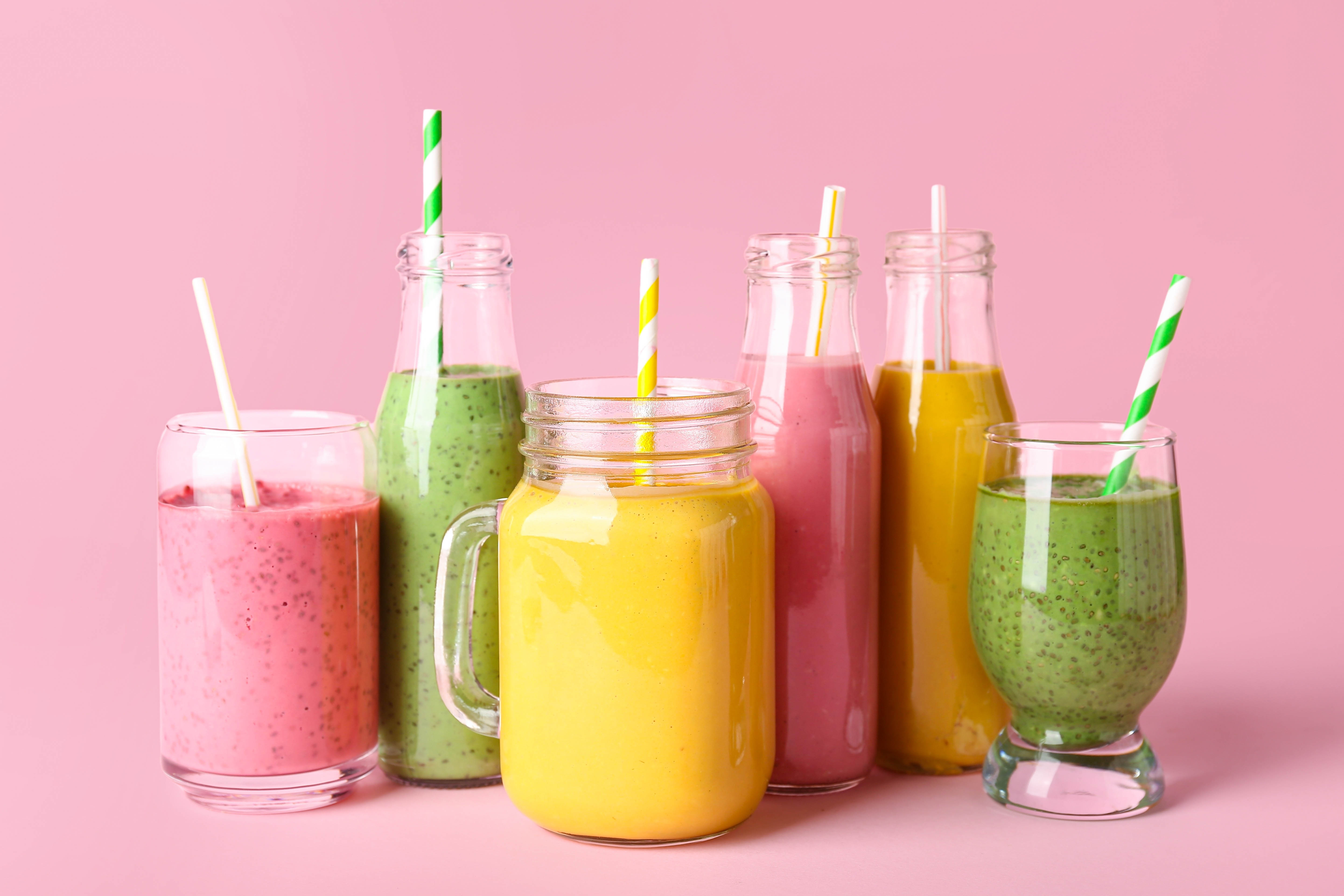 Various brightly coloured smoothies on a bright pink background Various brightly coloured smoothies on a bright pink background